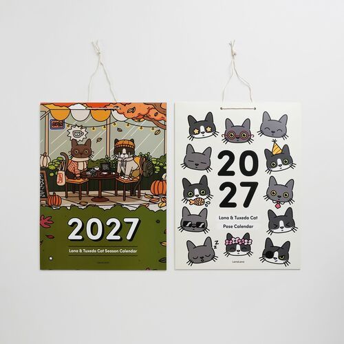Two charming cat-themed calendars hang side by side, showcasing colorful autumn scenes and adorable illustrated feline faces with playful details.