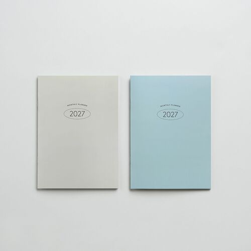 Two minimalist 2027 monthly planners with soft pastel covers, featuring clean typography and subtle branding, set against a plain white background.