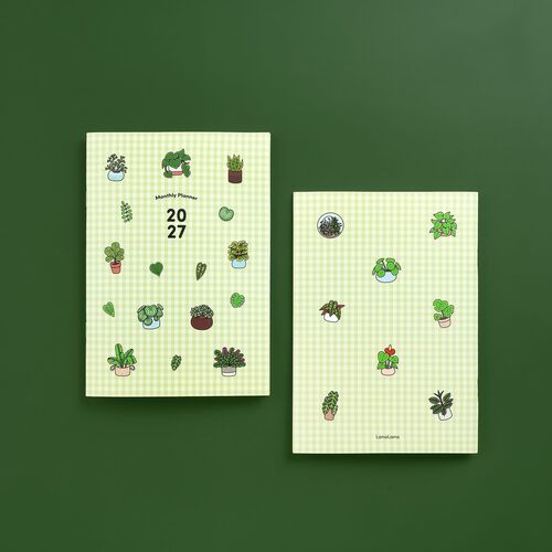 Two vibrant, plant-themed planners with green gingham covers and colorful illustrations, set against a matching green background, emphasizing freshness and creativity.