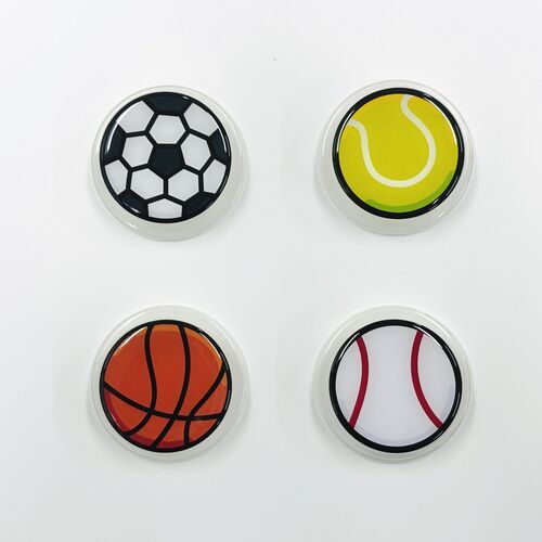 Four sports-themed magnetic grips with vibrant, glossy designs featuring soccer, tennis, basketball, and baseball motifs arranged on a white background.