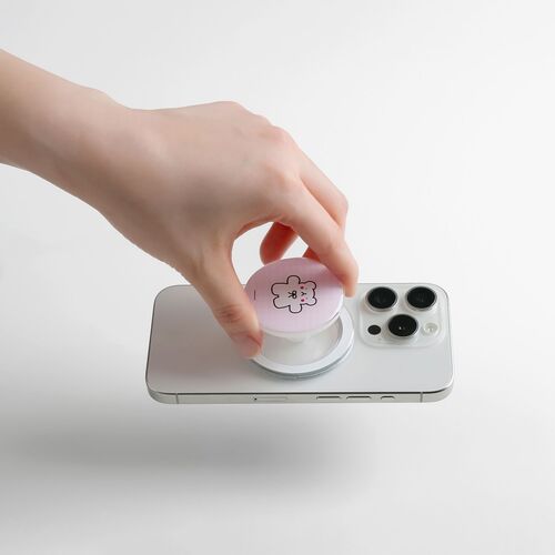A hand affixes the Seattle Magnetic Phone Grip onto a white smartphone, showcasing its playful design and magnetic functionality.