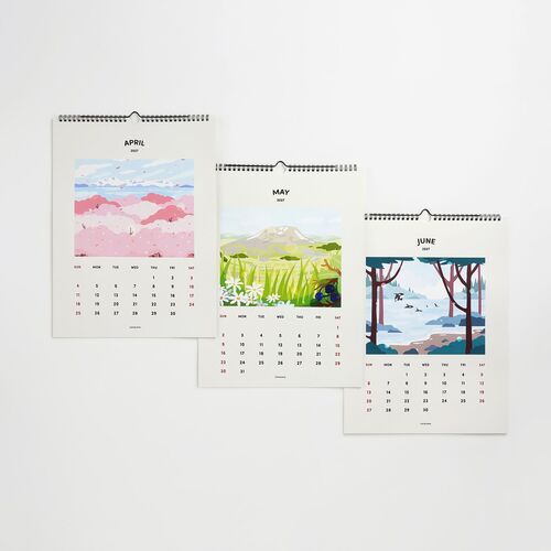Three monthly pages of the 2027 Seattle Wall Calendar are displayed, featuring vibrant, artistic landscape illustrations with clean white backgrounds.