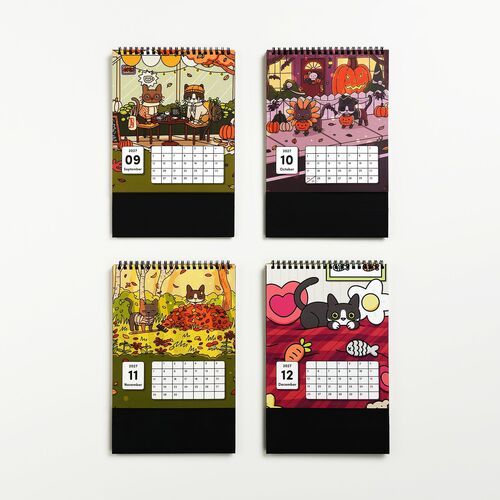 Four colorful, seasonal-themed Lana & Tuxedo Cat calendars are displayed with vibrant illustrations and clear monthly layouts on a white background.