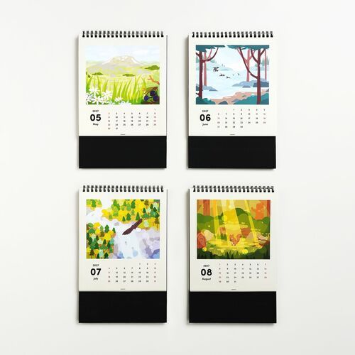 Four vibrant, illustrated calendar pages featuring lush nature scenes with colorful trees, mountains, and wildlife, arranged neatly on a white surface.