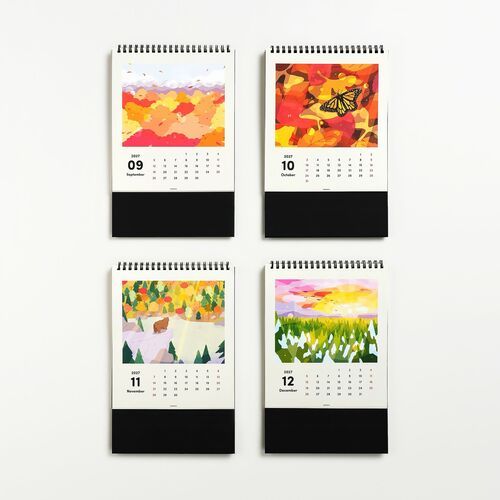 Four vibrant, colorful calendar pages featuring abstract autumn and nature scenes, with bold black bases and spiral bindings visible at the top.