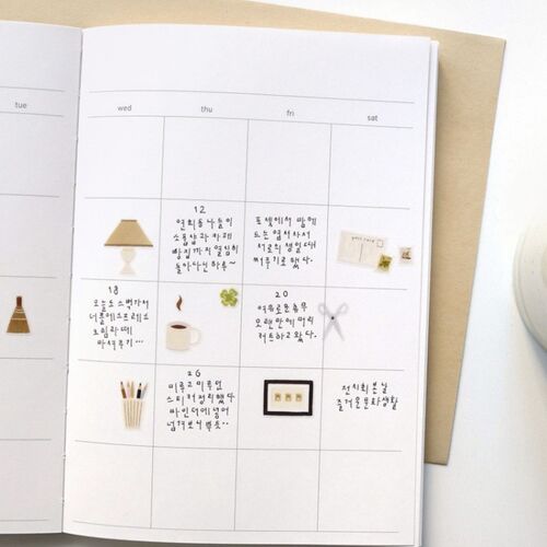 A close-up of a weekly planner page adorned with cute, minimalist stickers of lamps, cups, and stationery in soft, warm tones.