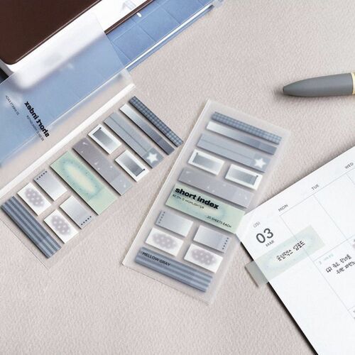 Close-up of pastel-colored sticky note sheets featuring various patterns, arranged neatly on a light textured surface, with a planner page nearby.