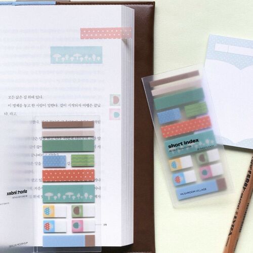 Colorful sticky notes with playful patterns are arranged on an open book, showcasing their vibrant designs and versatile use.