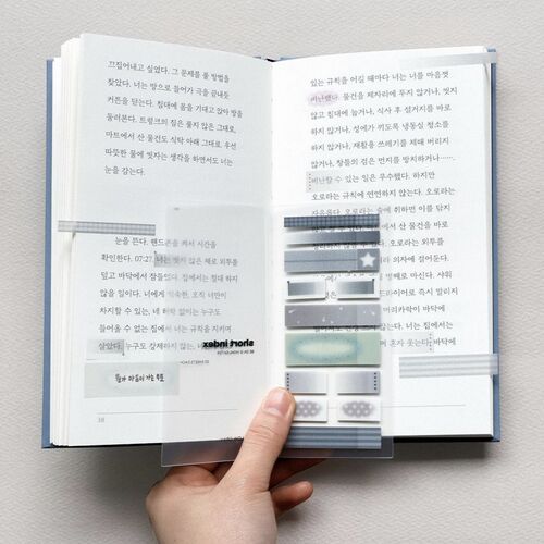 The open book showcases various sticky notes with subtle pastel tones and intricate patterns, highlighting their decorative and functional versatility.