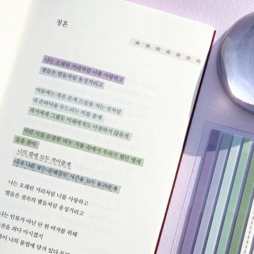 The image showcases a close-up of a long, transparent sticky note with a purple star pattern, partially torn, placed on a soft purple background.