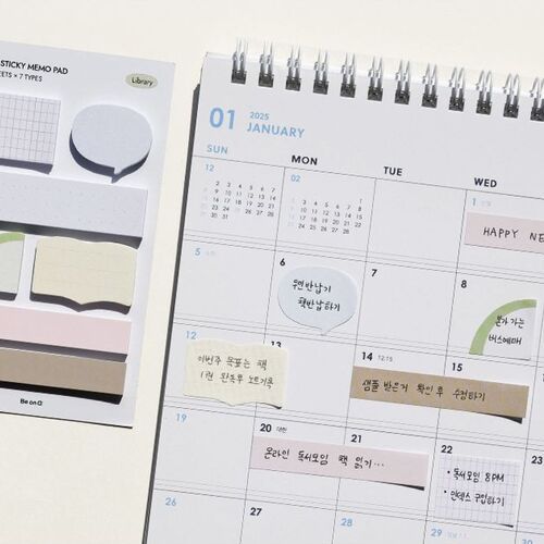 The image showcases a set of mini sticky notes with various shapes and colors, positioned next to a spiral-bound calendar page, emphasizing organization and aesthetic appeal.