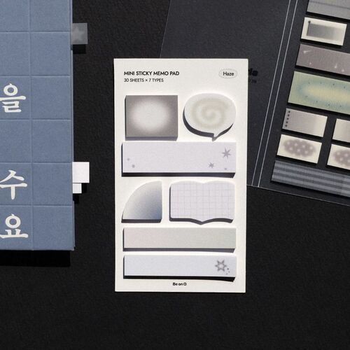 The image showcases a white sheet of mini sticky notes with various shapes and designs, emphasizing their aesthetic appeal and organization utility.