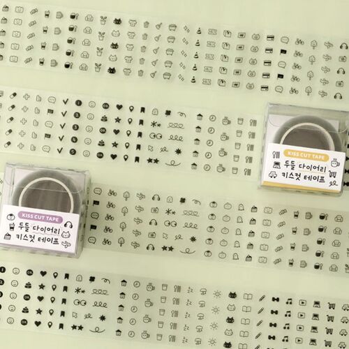 Two small, clear plastic cases containing Kiss Cut Tape with adorable black-and-white doodle icons, set against a plain background.