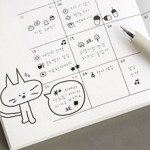 The image showcases a neatly arranged weekly planner page decorated with adorable doodle illustrations, including a cute cat and speech bubble, with a white pen placed nearby.