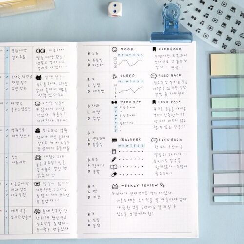 {
  "description": "The image showcases a neatly organized journal page with handwritten notes, colorful stickers, and doodles, complemented by the tape roll and applicator tools nearby.",
  "visual_analysis": {
    "colors": {
      "primary": "white",
      "secondary": "black",
      "accent": "blue",
      "palette": ["white", "black", "blue"],
      "color_family": "cool"
    },
    "materials": {
      "primary_material": "paper",
      "secondary_materials": ["plastic" (for tape dispenser and tweezers)],
      "texture": "smooth",
      "finish": "matte"
    },
    "style": {
      "aesthetic": "cute",
      "tags": ["organized", "playful", "creative"]
    },
    "composition": {
      "angle": "top-down/flat-lay",
      "lighting": "bright, even natural or studio lighting",
      "background": "light blue surface"
    },
    "setting": {
      "type": "studio/flat-lay",
      "context": "creative journaling workspace with decorative tape and planning notes"
    }
  }
}