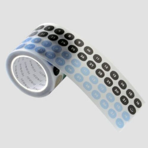 The tape features a playful arrangement of numbered black and blue circles on a matte white background, partially unrolled to reveal its pattern.