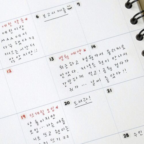 A close-up of a spiral-bound planner page showcasing handwritten Korean notes, with colorful red and black ink, highlighting the product's playful and organized aesthetic.