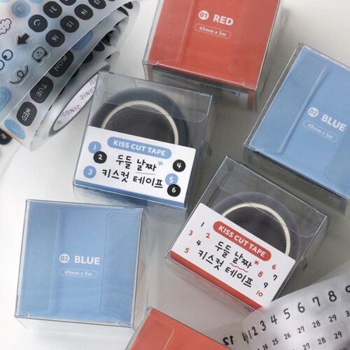 Colorful doodle tape rolls in clear plastic cases with cute labels, featuring playful Korean text and a mix of red and blue accents.
