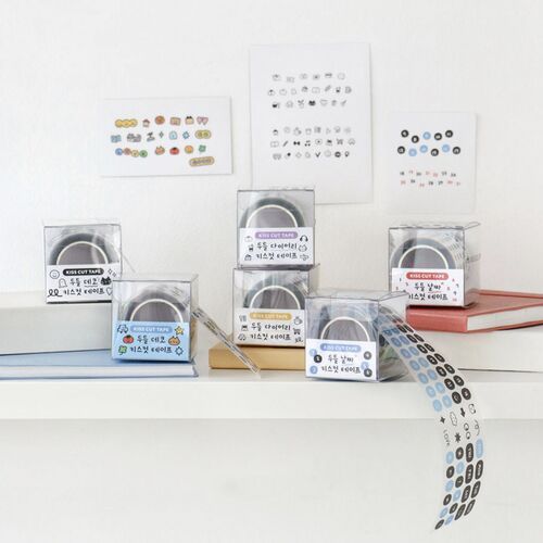 Colorful sticker tapes with playful doodle designs are displayed in clear cases, featuring a variety of icons, numbers, and days on a white background.