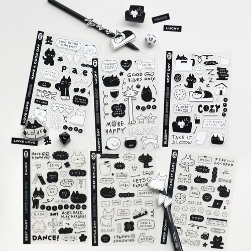 Black and white doodle stickers featuring cats, bears, and icons are displayed on sheets with a pen, highlighting their playful, removable design.