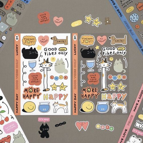 Two sheets of colorful doodle stickers featuring playful cats, stars, and hearts, arranged on a gray background with additional design elements.