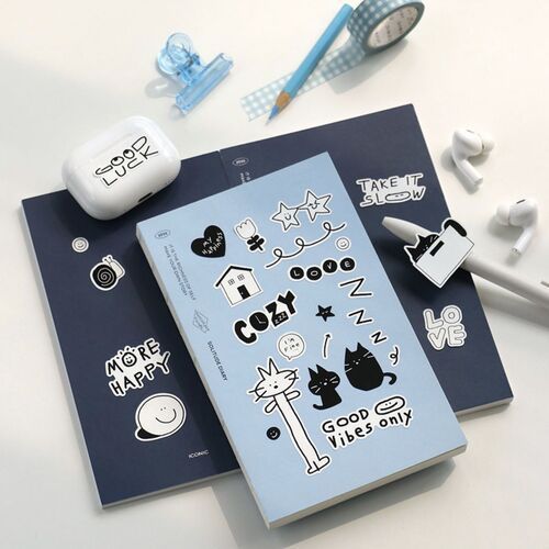 The image showcases a playful collection of doodle stickers, featuring black and pastel blue designs, arranged on notebooks with various stationery items around.