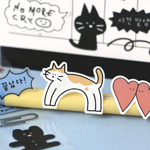 Colorful doodle stickers featuring playful cats, hearts, and speech bubbles are arranged on a light blue surface, highlighting their cute, whimsical style.