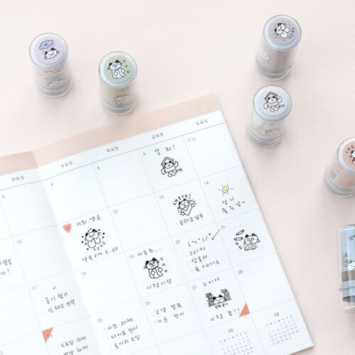 The image displays several cute, illustrated cat-themed self-inking stamps arranged around a planner page, highlighting their playful designs and compact size.