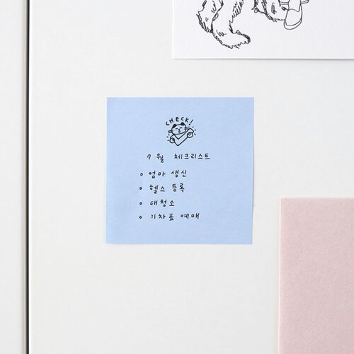 The image showcases a white surface with colorful sticky notes, including a blue one with a cute cat illustration and handwritten Korean text.