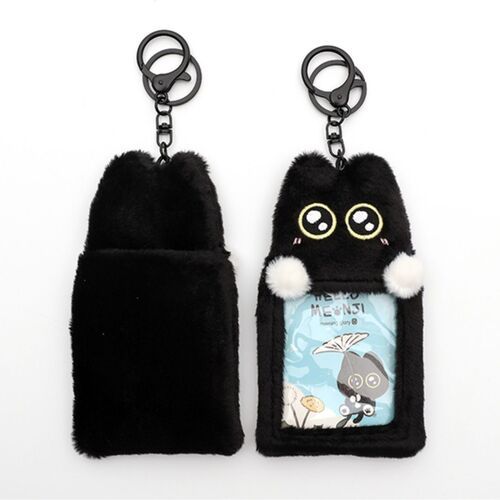 Two plush black cat key rings with expressive embroidered eyes and white pom-poms, one showcasing a clear photocard window against a white background.