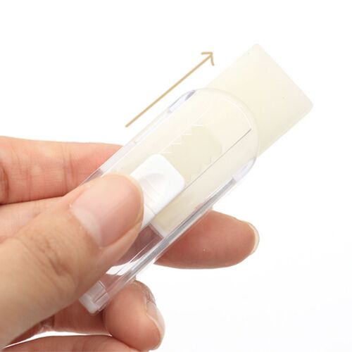A hand holds a clear plastic mini retractable eraser with a white erasing tip, partially extended against a plain white background.
