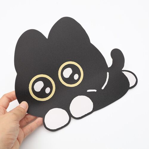 A playful black cat mouse pad with large, expressive eyes and white paws, held against a plain white background.