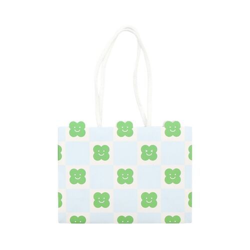 The small gift bag features a playful checkered pattern with cheerful green clover faces on a light blue background, accented by white handles.