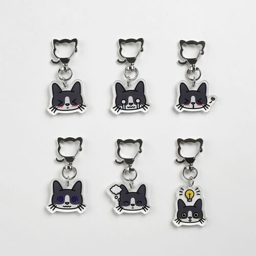 Six acrylic tuxedo cat emoji key rings with expressive faces and playful details, arranged neatly against a plain white background.