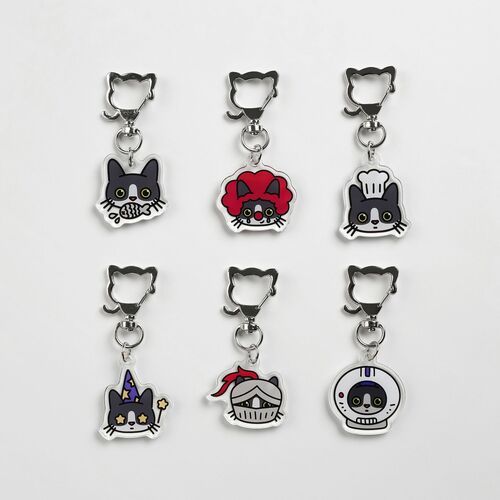 Six colorful acrylic key rings featuring playful tuxedo cat faces with various expressions and accessories, arranged neatly on a white background.