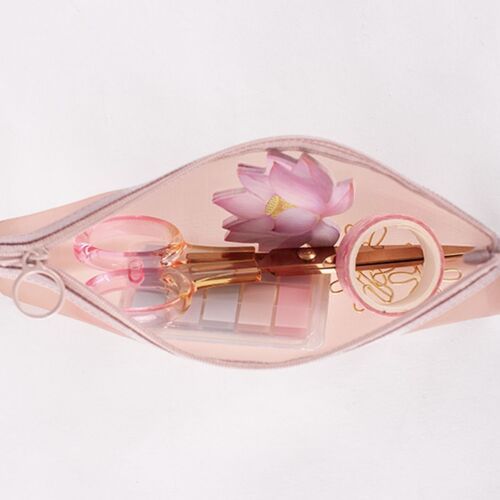 The pink mesh pouch with a subtle sheen is partially unzipped, revealing delicate pink scissors, a flower-shaped ring, and gold paper clips inside.