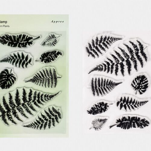 A clear plastic sheet displaying detailed black fern leaf stamps alongside a printed guide, highlighting intricate designs for precise crafting.