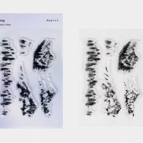 Transparent silicone stamps with intricate leaf and mountain designs are displayed on a white background, showcasing detailed impressions and clean edges.