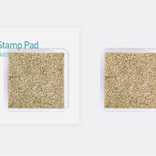 The metallic shimmer stamp pad features a clear plastic case revealing a densely packed, glittering gold surface with a smooth, glossy finish.