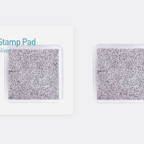 Two metallic shimmer stamp pads in silver, housed in clear plastic cases, with one partially covered by a branded packaging label.