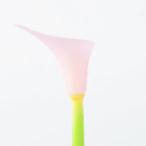 A pastel pink flower-shaped silicone body with a bright yellow stem, slightly wobbling against a plain white background, emphasizing its playful design.