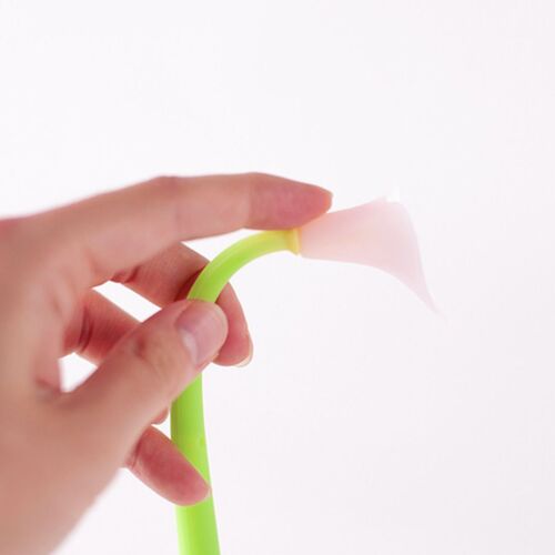 A delicate pink flower head with a soft, translucent appearance rests atop a bright green silicone stem, held gently by a person's hand.