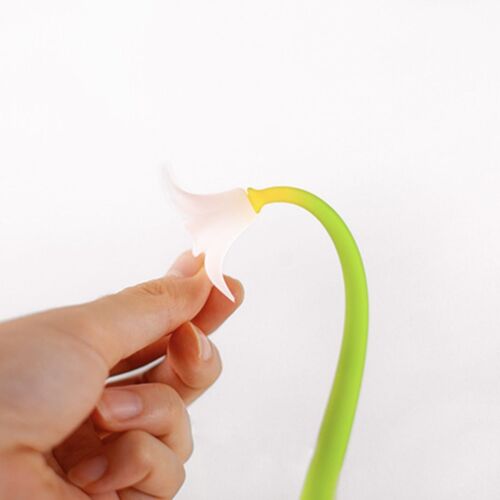A close-up of a hand holding a delicate white flower-shaped accessory attached to a bright green, flexible silicone stem against a plain white background.