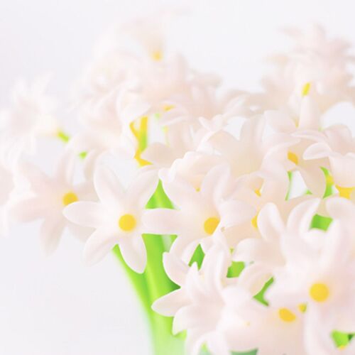 A cheerful cluster of pastel pink and yellow flowers with bright green stems, softly illuminated against a white background.