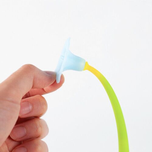 A hand holds the soft, flexible silicone body of the wobbling flower gel pen, with a bright yellow and blue tip against a plain white background.