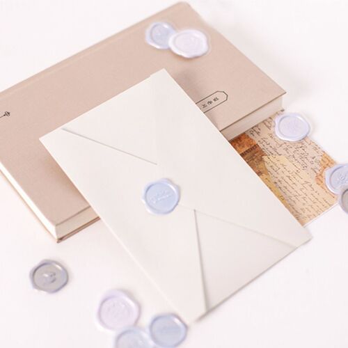 The image showcases a set of self-adhesive sealing wax stickers in pastel shades, arranged on a soft, neutral-toned background with an envelope and decorative paper.