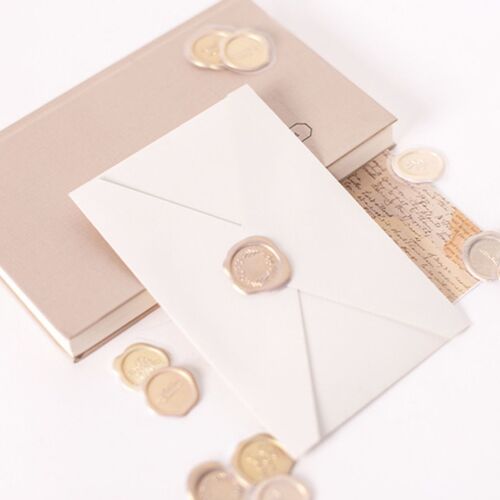 Elegant wax sticker set with six vibrant colors and embossed floral and word designs, arranged on a soft beige background with scattered wax seals.