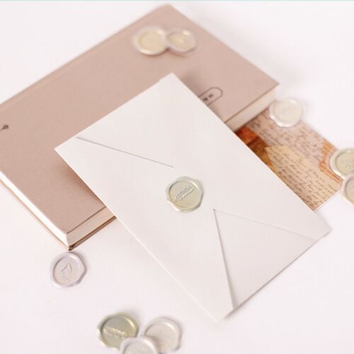 Elegant sealing wax stickers with embossed floral and word designs in soft pastel shades, displayed on a clean white surface.