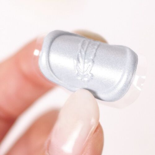 A close-up of a silver sealing wax sticker with embossed floral details, showing its glossy finish and self-adhesive backing.