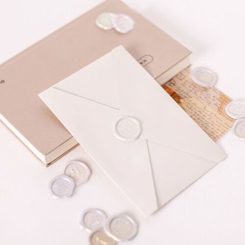 Elegant self-adhesive sealing wax stickers in six vibrant colors and intricate designs are displayed on a white surface, enhancing stationery charm.